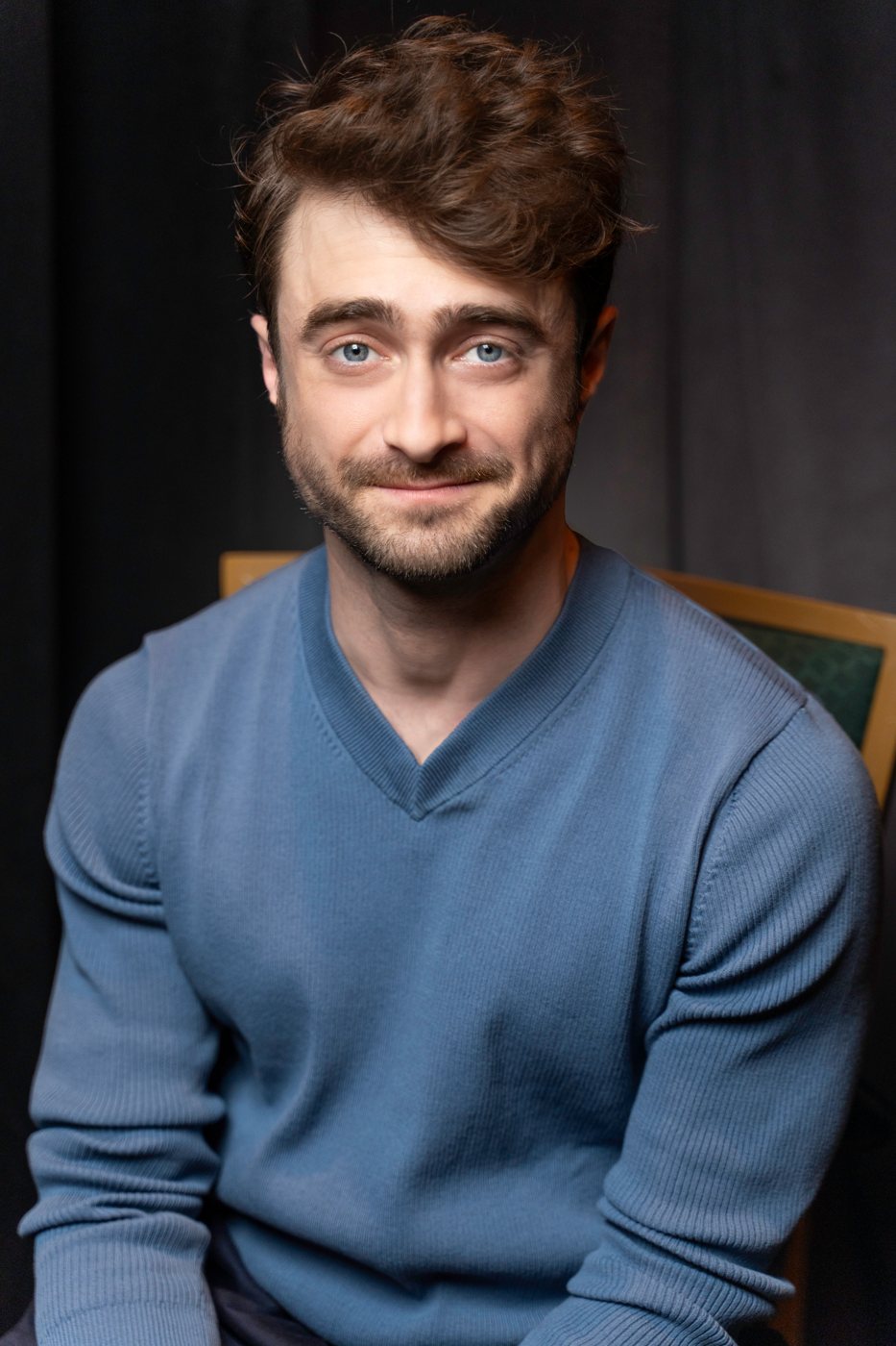 Seated portrait of an actor in a blue sweater