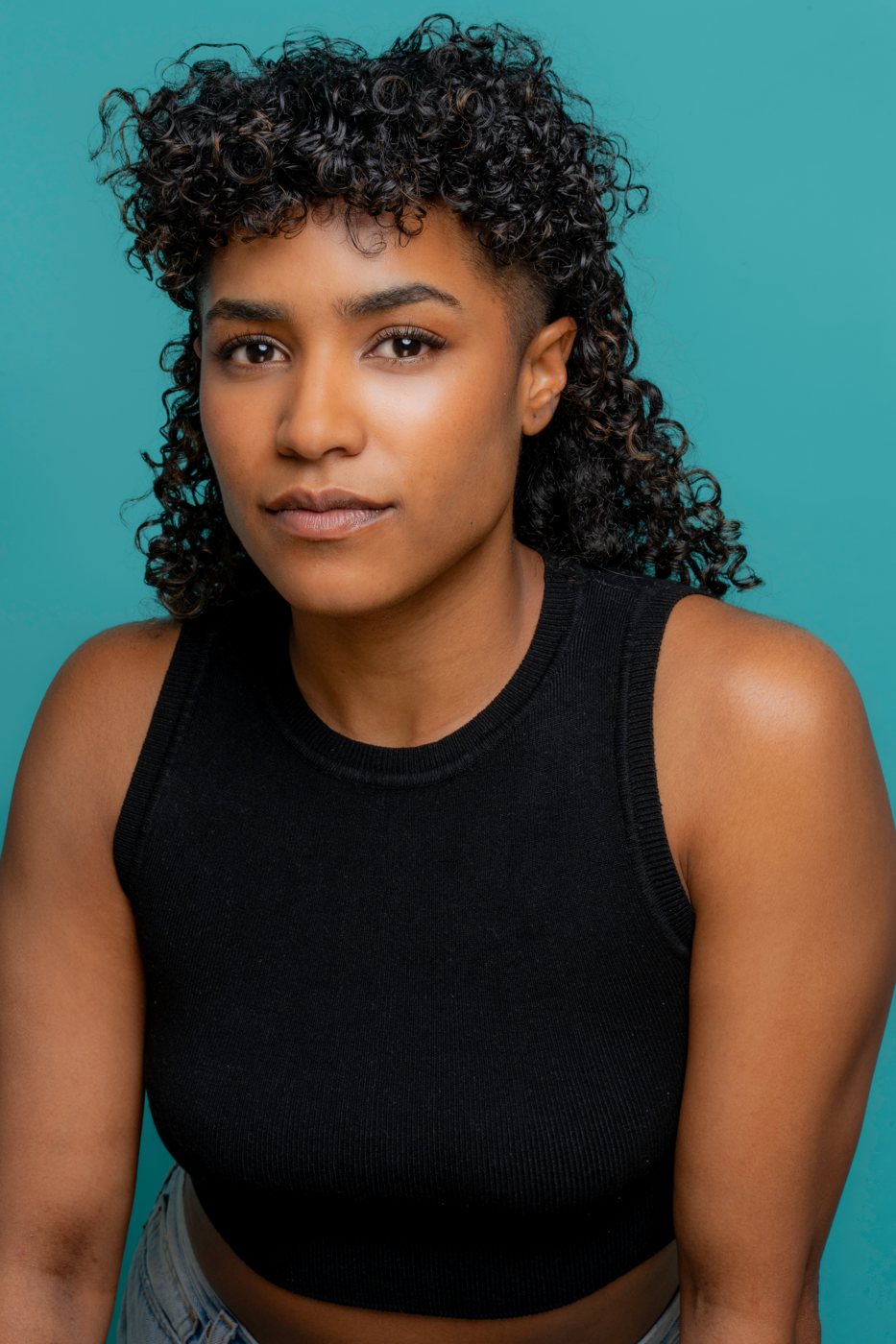Headshot of an actor on a teal backdrop