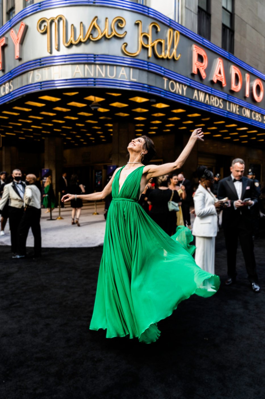 A guest twirls in a green gown outside Radio City Music Hall at the Tony Awards