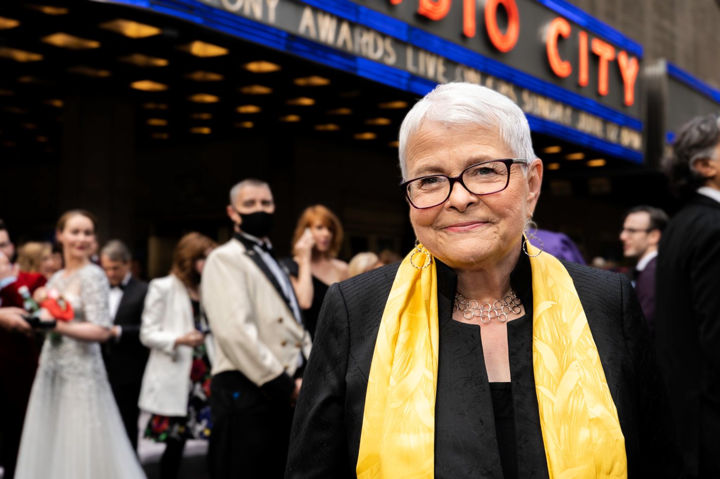Red carpet portrait in a yellow scarf outside Radio City Music Hall at the Tony Awards